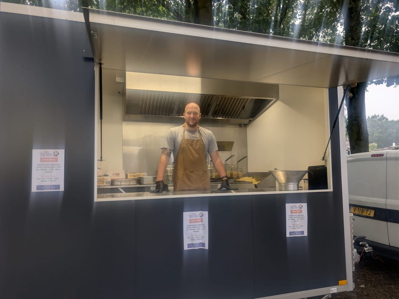Aan het werk achter het luik van de frietwagen